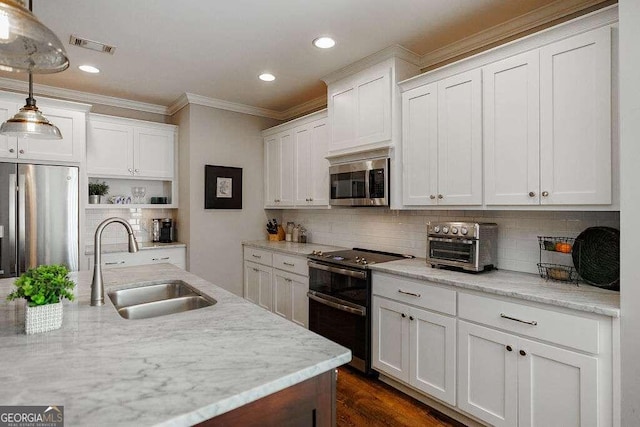 kitchen with light stone countertops, white cabinetry, sink, hanging light fixtures, and appliances with stainless steel finishes