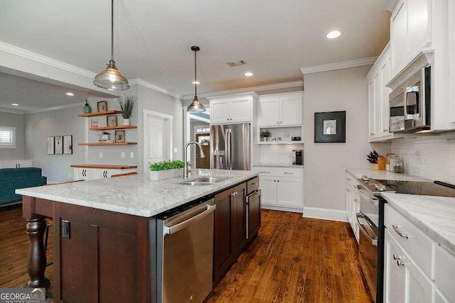 kitchen with light stone counters, stainless steel appliances, dark wood-type flooring, sink, and an island with sink