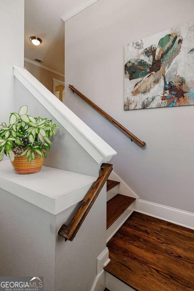 stairs with crown molding and hardwood / wood-style floors