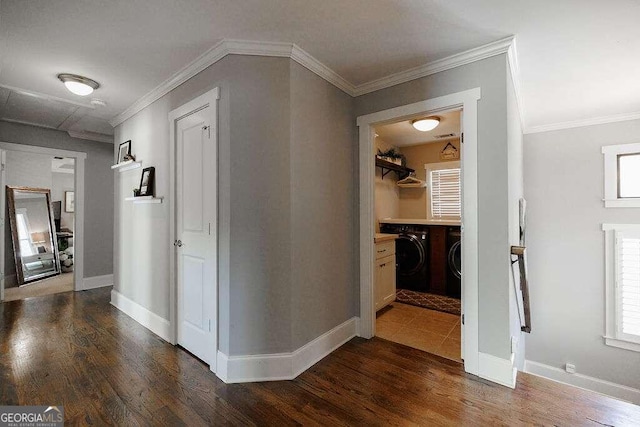 hallway with separate washer and dryer, dark hardwood / wood-style floors, and ornamental molding