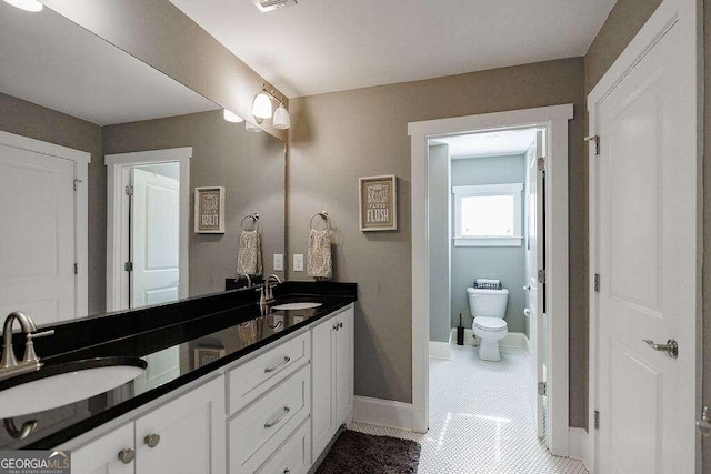 bathroom featuring tile patterned flooring, vanity, and toilet