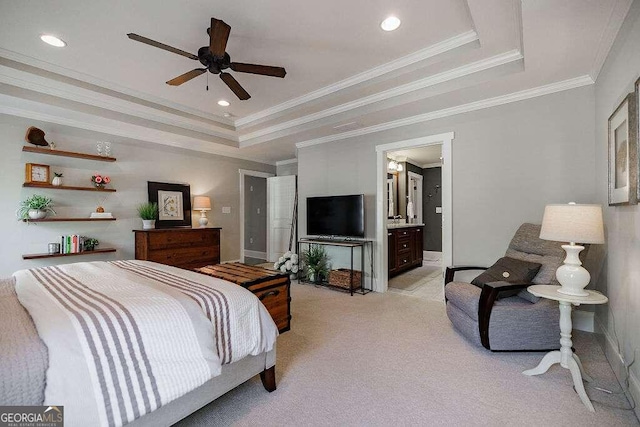 carpeted bedroom featuring ceiling fan, ornamental molding, ensuite bathroom, and a tray ceiling