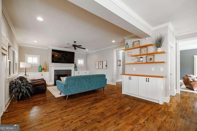 living room with dark hardwood / wood-style flooring, a wealth of natural light, and crown molding