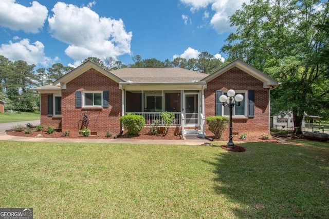 ranch-style house with a front yard and a sunroom