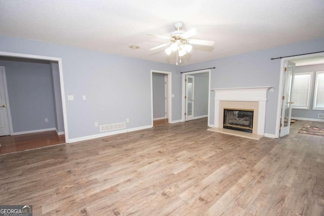 611 Bernhard Rd, Fayetteville, GA 30215 - unfurnished living room featuring a ceiling fan, a glass covered fireplace, and wood finished floors