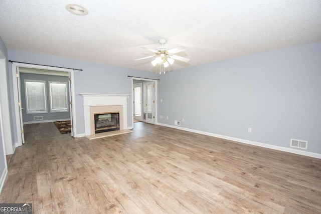 611 Bernhard Rd, Fayetteville, GA 30215 - unfurnished living room featuring light wood-type flooring, ceiling fan, and a glass covered fireplace
