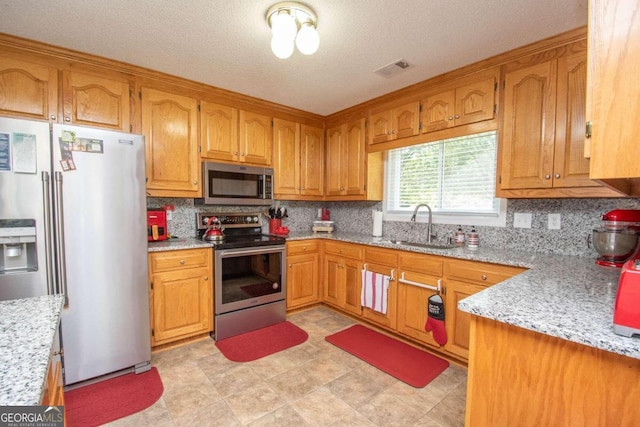 611 Bernhard Rd, Fayetteville, GA 30215 - kitchen with stainless steel appliances, decorative backsplash, brown cabinets, light stone countertops, and a textured ceiling