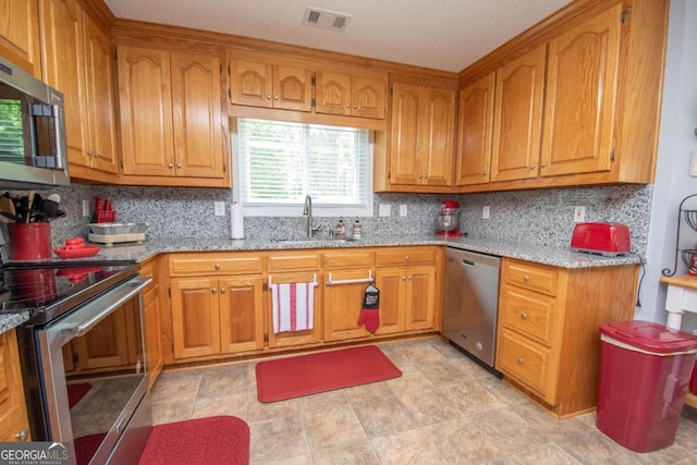 611 Bernhard Rd, Fayetteville, GA 30215 - kitchen with stainless steel appliances, brown cabinets, and light stone countertops