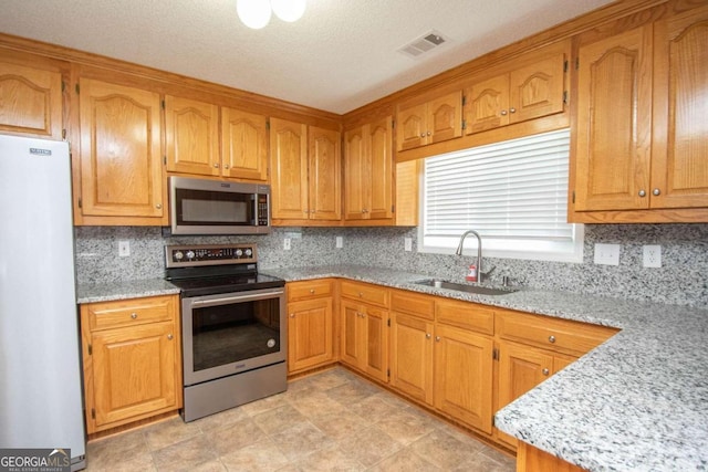 611 Bernhard Rd, Fayetteville, GA 30215 - kitchen with appliances with stainless steel finishes, tasteful backsplash, light stone countertops, and brown cabinetry