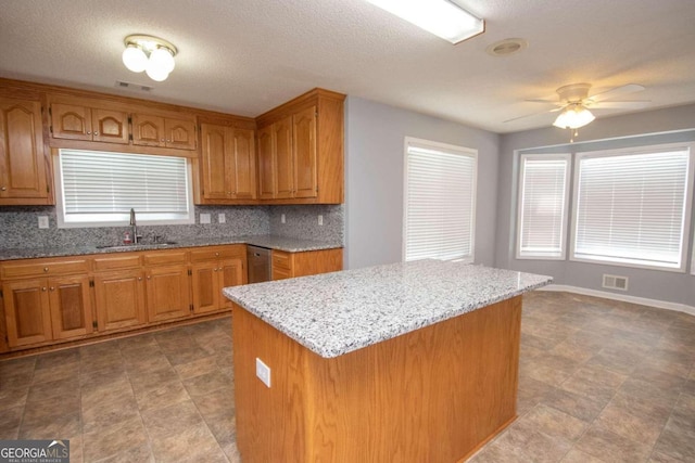 611 Bernhard Rd, Fayetteville, GA 30215 - kitchen featuring brown cabinets, light stone counters, backsplash, and a textured ceiling