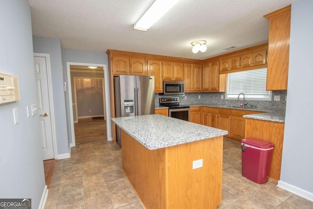 611 Bernhard Rd, Fayetteville, GA 30215 - kitchen with stainless steel appliances, a kitchen island, decorative backsplash, brown cabinetry, and a textured ceiling