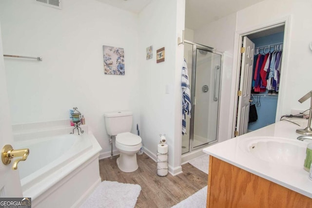 611 Bernhard Rd, Fayetteville, GA 30215 - bathroom with a shower stall, wood finished floors, a bath, vanity, and a walk in closet