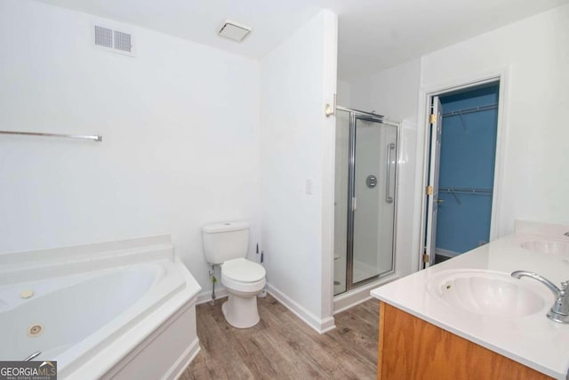 611 Bernhard Rd, Fayetteville, GA 30215 - bathroom with wood finished floors, a shower stall, a jetted tub, double vanity, and a spacious closet