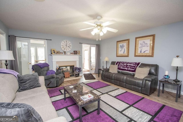 611 Bernhard Rd, Fayetteville, GA 30215 - living area with plenty of natural light, ceiling fan, wood finished floors, a textured ceiling, and a glass covered fireplace