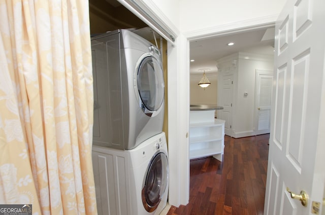 clothes washing area with dark hardwood / wood-style flooring and stacked washer and dryer