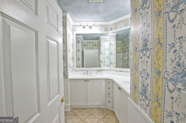 bathroom featuring tile patterned flooring, vanity, walk in shower, and crown molding