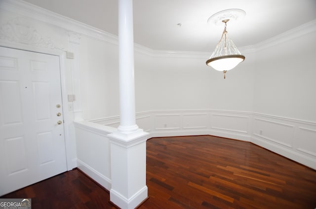 foyer featuring ornate columns, crown molding, and dark wood-type flooring