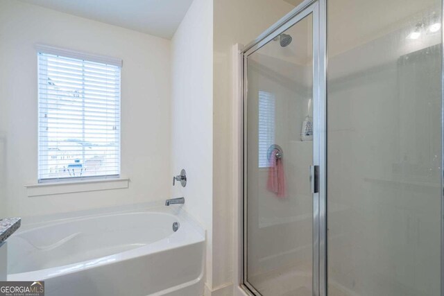 bathroom featuring separate shower and tub and a healthy amount of sunlight