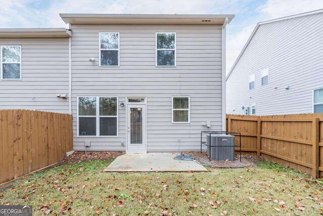 back of house featuring a patio area, a yard, and central AC