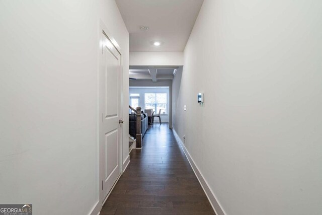 hallway with beam ceiling and dark wood-type flooring