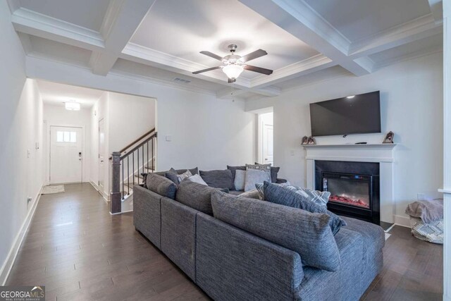 living room featuring beam ceiling, crown molding, dark wood-type flooring, and coffered ceiling