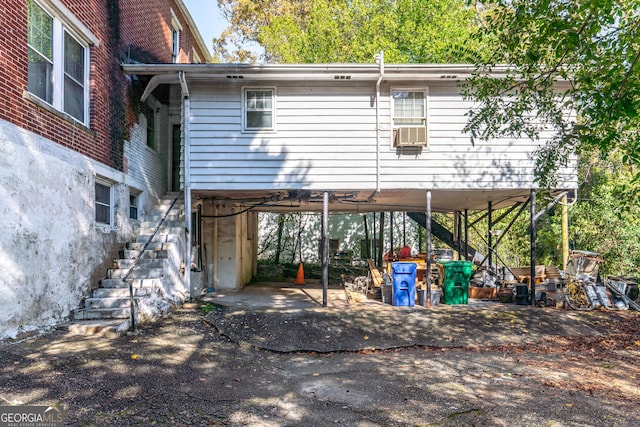 rear view of house featuring a carport and cooling unit