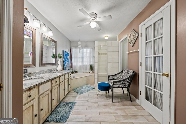 bathroom with vanity, a textured ceiling, a bathtub, and ceiling fan