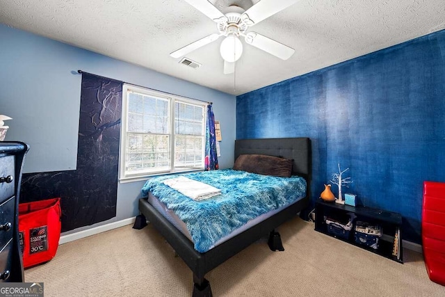 carpeted bedroom featuring a textured ceiling and ceiling fan