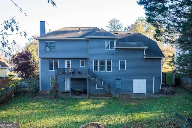 rear view of house featuring a deck, a yard, and a patio