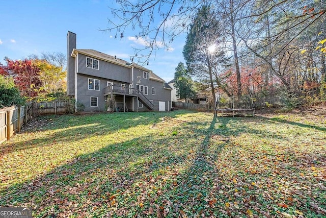 view of yard featuring a wooden deck and a trampoline