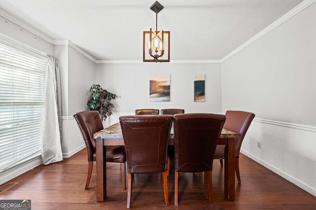 dining space featuring ornamental molding, dark wood-type flooring, and a notable chandelier