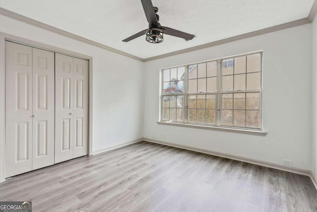 unfurnished bedroom featuring a closet, crown molding, ceiling fan, and light hardwood / wood-style floors