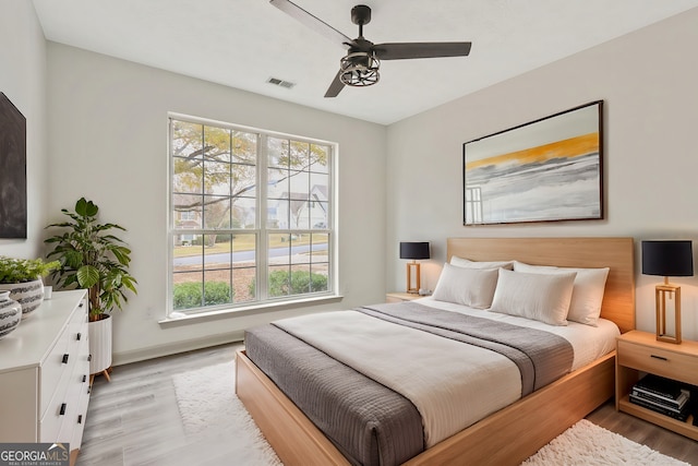 bedroom with multiple windows, ceiling fan, and light hardwood / wood-style flooring