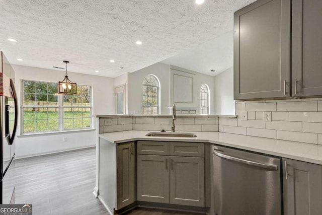 kitchen featuring a textured ceiling, stainless steel appliances, gray cabinets, and sink