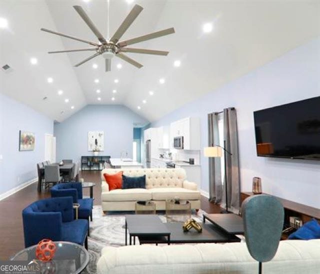 living room featuring wood-type flooring, vaulted ceiling, and ceiling fan