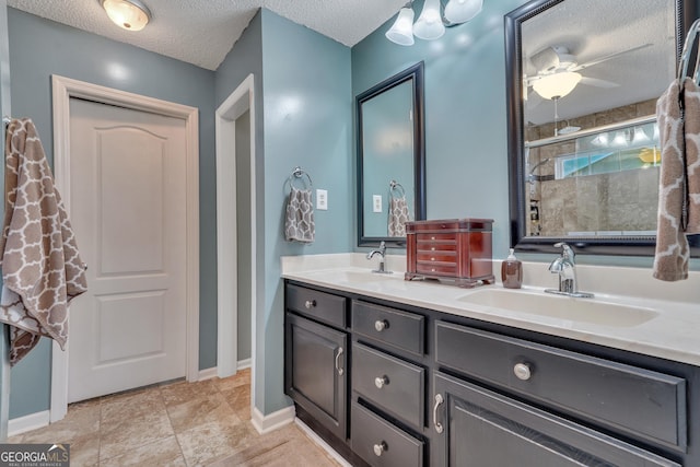 bathroom with tile patterned floors, vanity, a textured ceiling, ceiling fan, and a shower with shower door