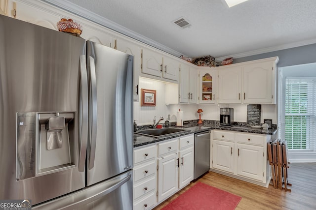 kitchen featuring light wood-type flooring, stainless steel appliances, white cabinetry, and sink