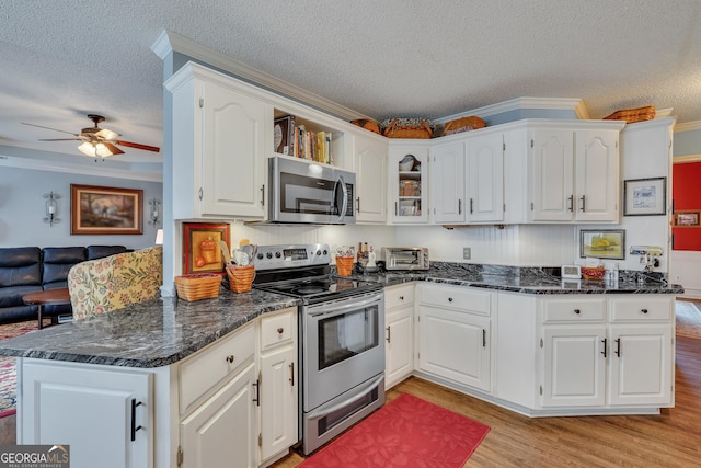 kitchen featuring white cabinetry, stainless steel appliances, a textured ceiling, and light hardwood / wood-style floors