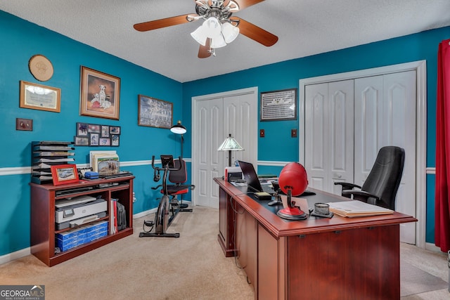 office area featuring a textured ceiling, ceiling fan, and light carpet