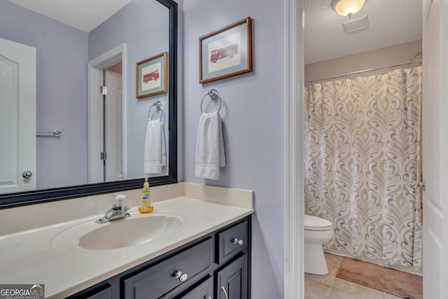 bathroom featuring vanity, tile patterned floors, a textured ceiling, and toilet