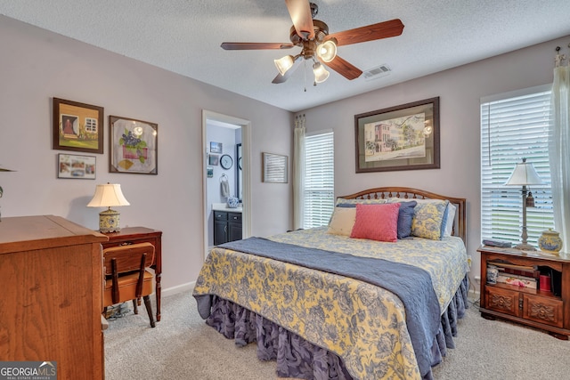 bedroom featuring connected bathroom, ceiling fan, light colored carpet, and multiple windows