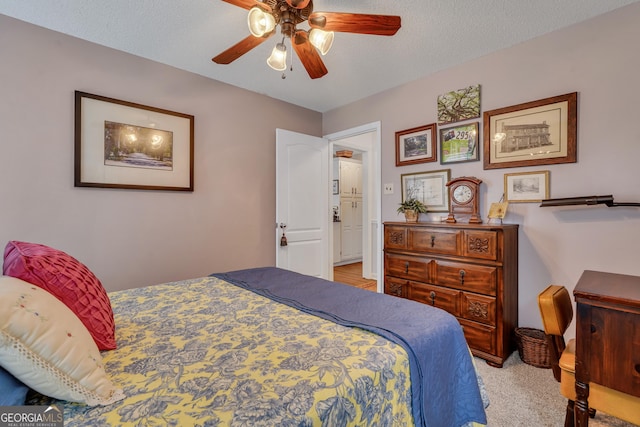 carpeted bedroom with a textured ceiling and ceiling fan