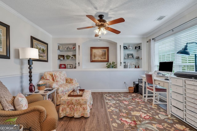 office with hardwood / wood-style flooring, built in shelves, crown molding, and a textured ceiling