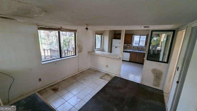 interior space with light tile patterned flooring and white appliances