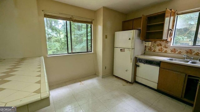 kitchen with a wealth of natural light, sink, and white appliances