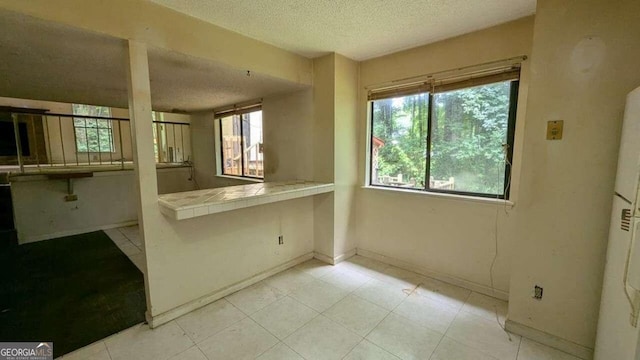 kitchen featuring tile counters and a textured ceiling