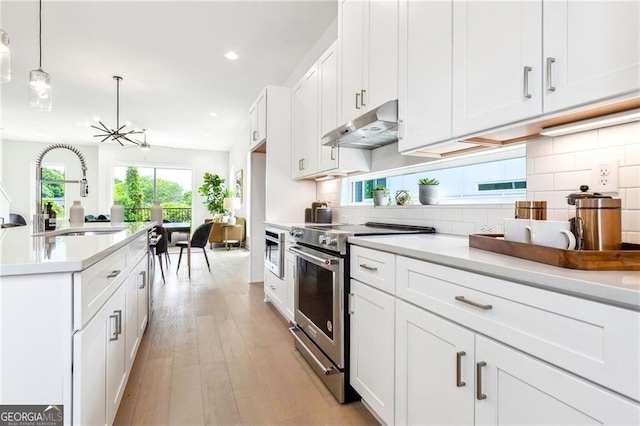 kitchen with pendant lighting, white cabinetry, sink, and stainless steel appliances