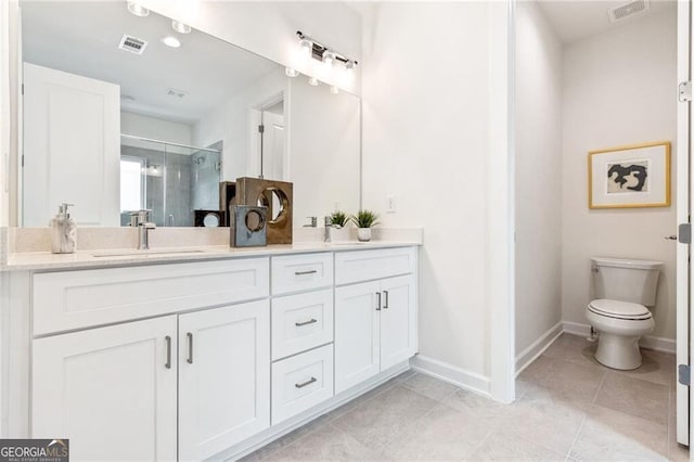 bathroom with tile patterned floors, vanity, toilet, and a shower with door