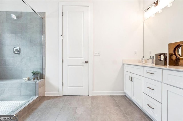 bathroom with tile patterned floors, vanity, and tiled shower