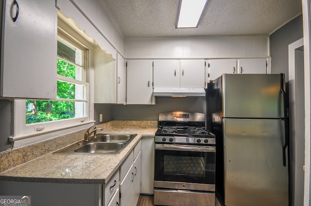 kitchen with white cabinets, sink, stainless steel appliances, and a textured ceiling